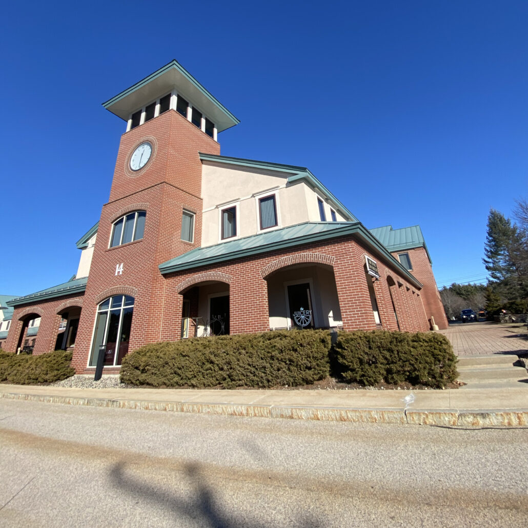 Exterior of The Juicery’s Pease Tradeport location inside a brick building with a clock tower.